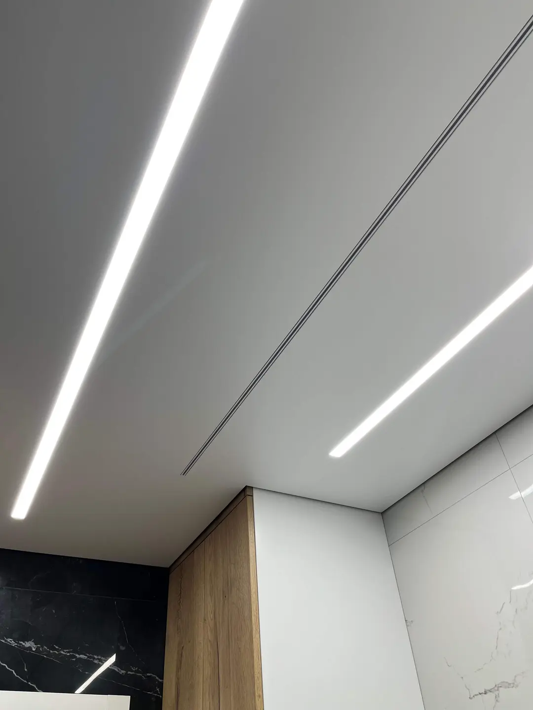 Líneas de luz y cortinero empotrado en un techo tensado – obra realizada